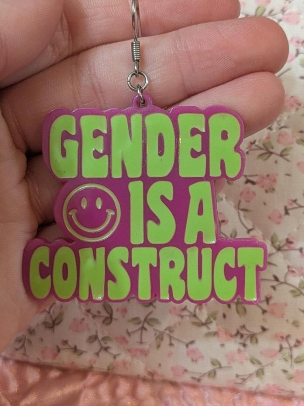 Handmade Gender is a construct earrings and keychain with green text and a smile